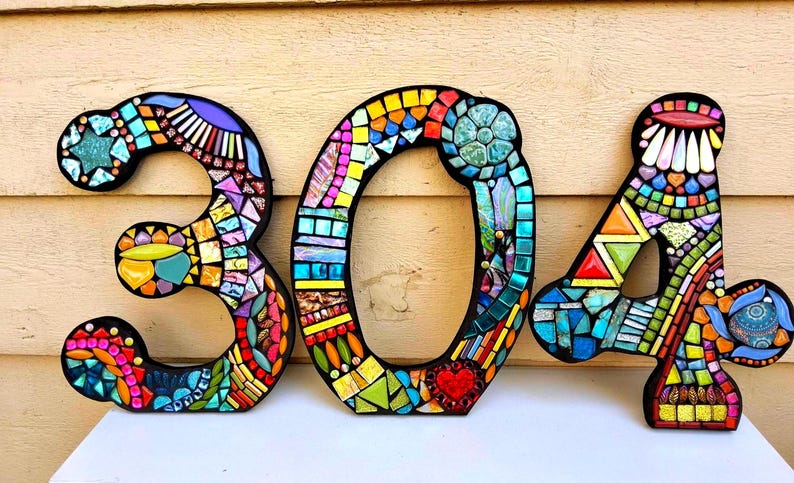 a creative and colorful display of mosaic tiles, forming the numbers "301" on a wall.