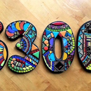 three colorful mosaic pieces arranged to spell out the numbers '5300'.