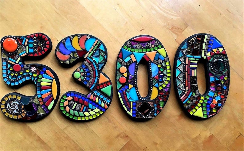 three colorful mosaic pieces arranged to spell out the numbers '5300'.
