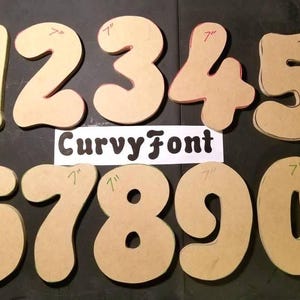 a collection of cardboard cutout numbers, including the numbers 1 through 9, with the Curvy Font logo displayed in the center.