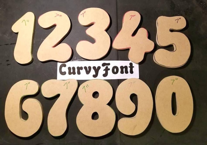 a collection of cardboard cutout numbers, including the numbers 1 through 9, with the Curvy Font logo displayed in the center.