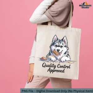 May include: Cream-colored tote bag featuring a cartoon husky dog with a hamburger in its mouth. The dog is gray, black, and white. The text "Quality Control Approved" is below the dog. The bag is held by a person.