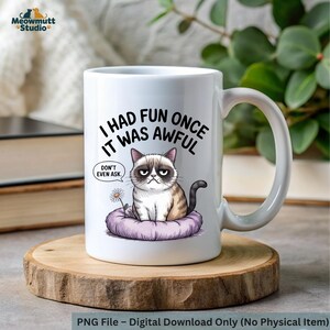 May include: White ceramic mug featuring a grumpy cat illustration with the text "I had fun once, it was awful." The cat is sitting on a purple cushion with a daisy. The mug has a large handle and is on a wooden coaster.
