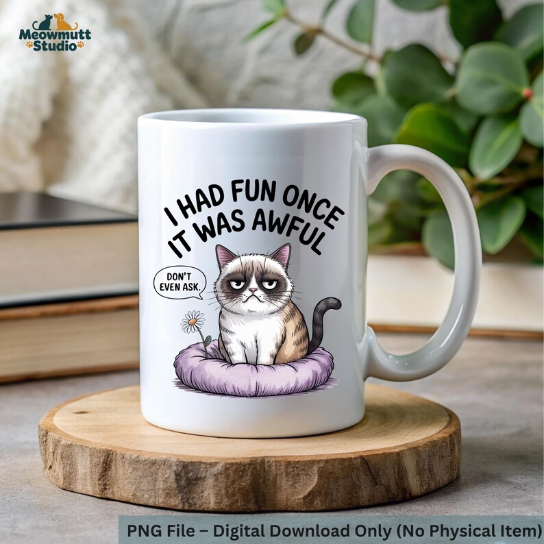 May include: White ceramic mug featuring a grumpy cat illustration with the text "I had fun once, it was awful." The cat is sitting on a purple cushion with a daisy. The mug has a large handle and is on a wooden coaster.