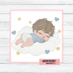 Pode incluir: Desenho bordado de um bebé a dormir numa nuvem, rodeado de estrelas e corações. O bebé usa roupa azul e uma fralda. O desenho é emoldurado em rosa e inclui o texto "MERRYBERRY EMBROIDERY".