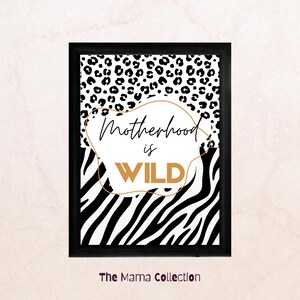 Puede incluir: Impresión artística enmarcada en negro con un diseño de estampado de leopardo y rayas de cebra. El texto "Motherhood is WILD" está en el centro, con un contorno dorado. "The Mama Collection" está en la parte inferior. Una pieza decorativa.