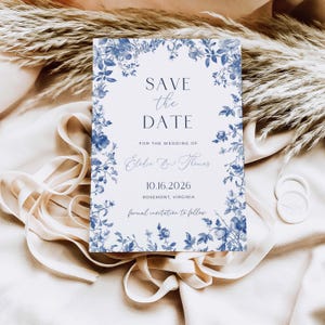 Peut inclure: Une carte Save the Date rectangulaire avec une bordure florale bleue et blanche. Le texte indique : SAVE the DATE, FOR THE WEDDING OF, Elodie & Thomas, 10.16.2026, ROSEMONT, VIRGINIA, formal invitation to follow. La carte est blanche avec du texte bleu.