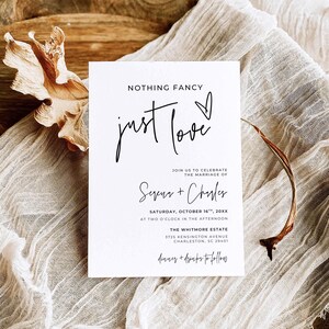 May include: A white rectangular wedding invitation card with black text that reads NOTHING FANCY just love, JOIN US TO CELEBRATE THE MARRIAGE OF Seena + Charles, SATURDAY, OCTOBER 16TH, 20XX, AT TWO O'CLOCK IN THE AFTERNOON, THE WHITMORE ESTATE, 3725 KENSINGTON AVENUE, CHARLESTON, SC 29401, dinner + drinks to follow.