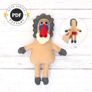 May include: A felt sewing pattern for a mandrill monkey plush toy. The pattern includes instructions for making the monkey's body, head, arms, legs, and nose. The pattern is available as a PDF download.