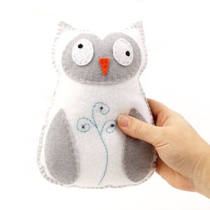 Hand holding a hand stitched plush snowy owl