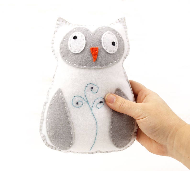 Hand holding a hand stitched plush snowy owl