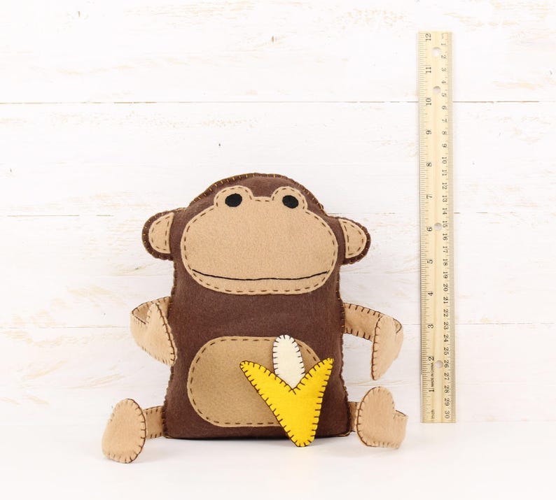 Felt monkey stuffed animal next to a ruler