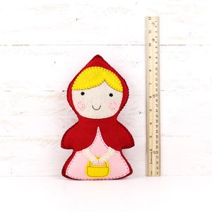 Plush felt Little Red Riding Hood next to a ruler to show size