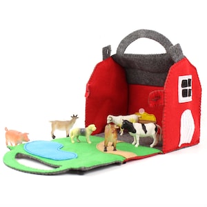 Hand sewn toy barn opened up with plastic farm animal toys inside