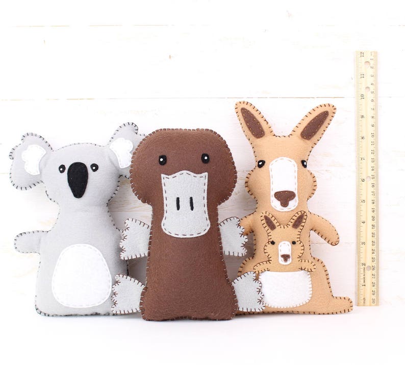 Plush koala, platypus, and kangaroo, next to a ruler to show relative size