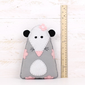 Felt hand sewn possum next to a ruler