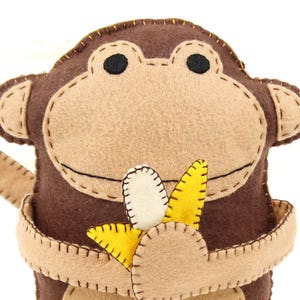 Handmade felt monkey clutching felt banana