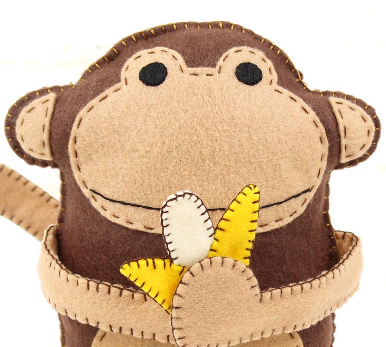 Handmade felt monkey clutching felt banana