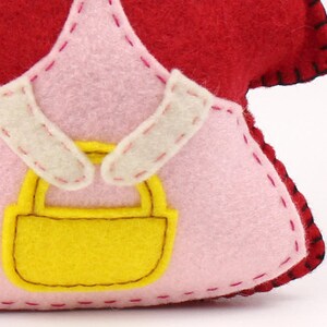 Close up of basket held by felt little red riding hood