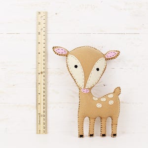 Felt deer stuffed animal next to a ruler