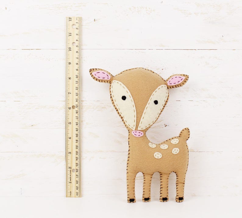 Felt deer stuffed animal next to a ruler