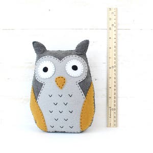 Felt plush owl next to a ruler to show relative size