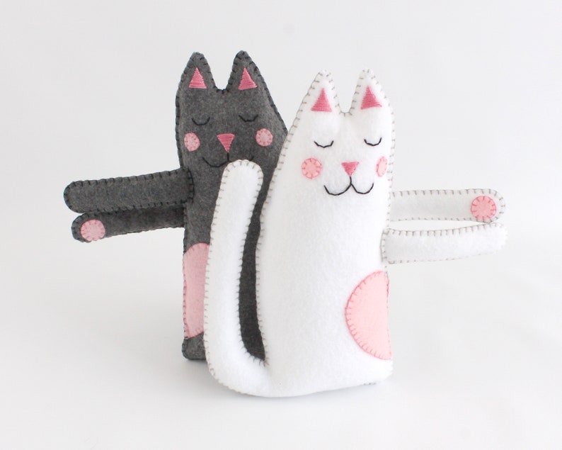 Two felt cats that have arms designed to hug eachother