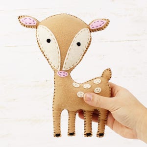 Hand holding a plush hand sewn fawn