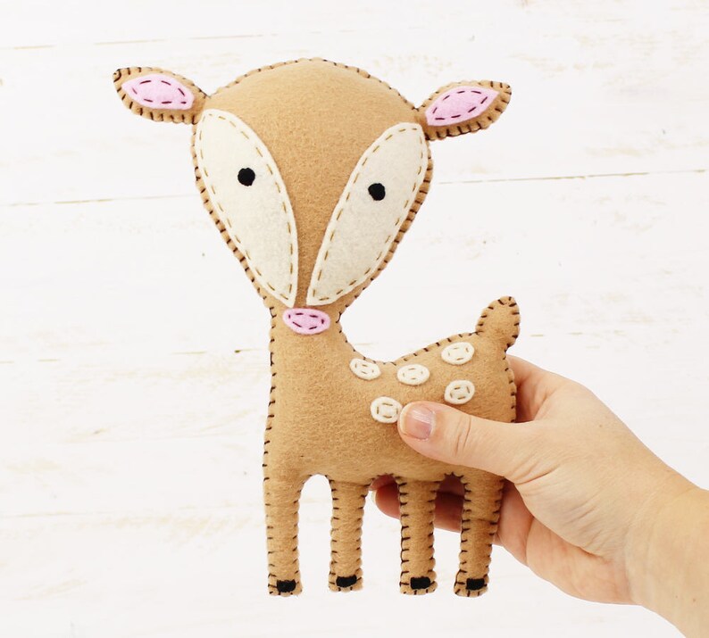 Hand holding a plush hand sewn fawn