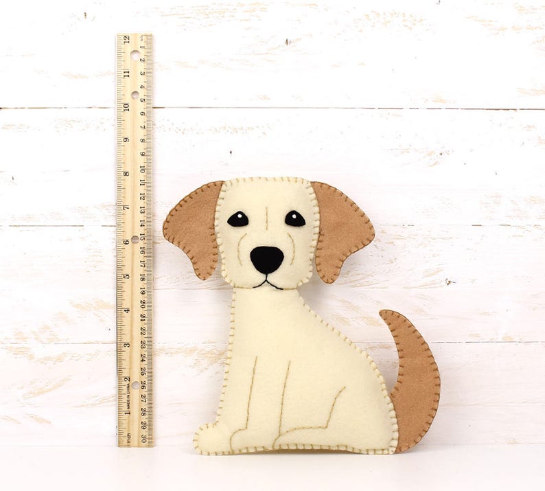 Felt plush golden lab puppy next to a ruler to show relative size