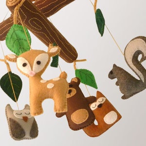 Woodland forest themed nursery mobile with hand sewn logs and leaves, and a baby deer, owl, bear, fox, and squirrel