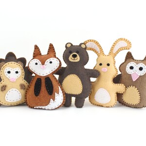 A set of five small woodland animals made from hand sewing patterns: a hedgehog, fox, bear, bunny, and owl