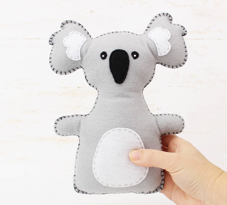 Light gray plush koala bear hand sewn with felt and embroidery floss, held in a hand