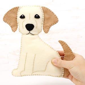 Hand holding a plush felt hand sewn dog