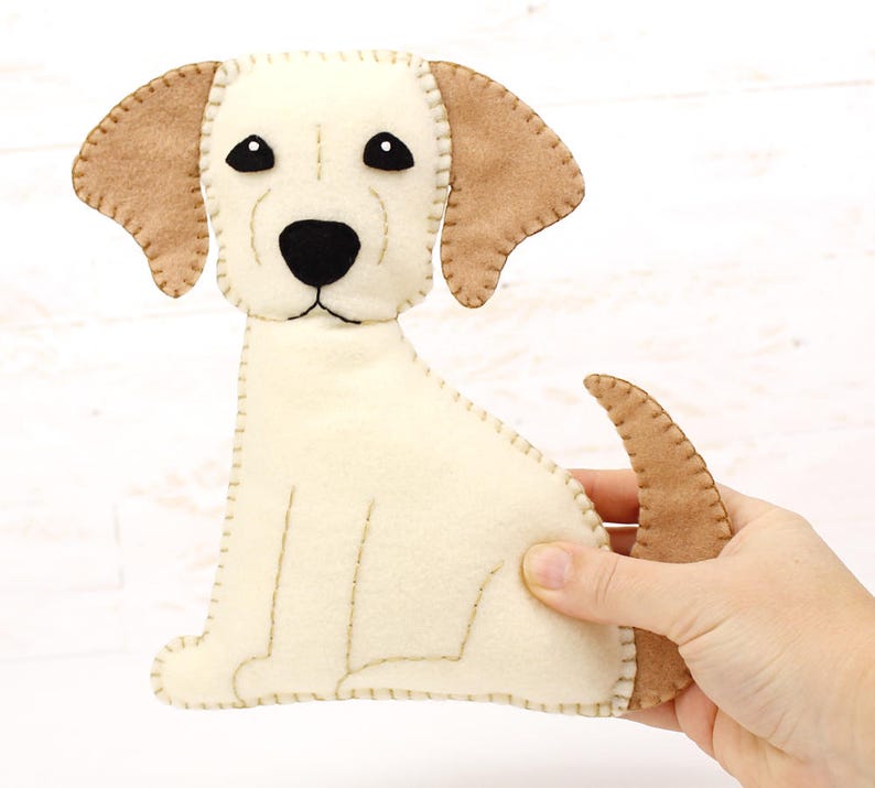 Hand holding a plush felt hand sewn dog