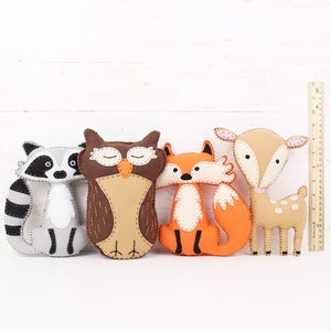 Felt plush forest animals next to a ruler to show relative size