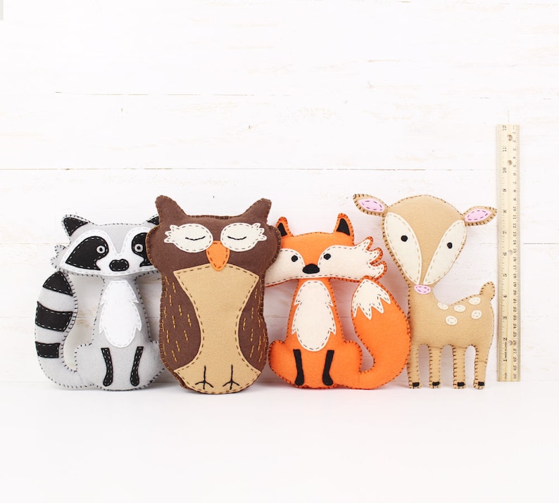 Felt plush forest animals next to a ruler to show relative size