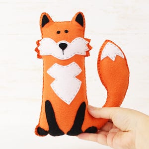 Hand holding a plush felt hand sewn fox