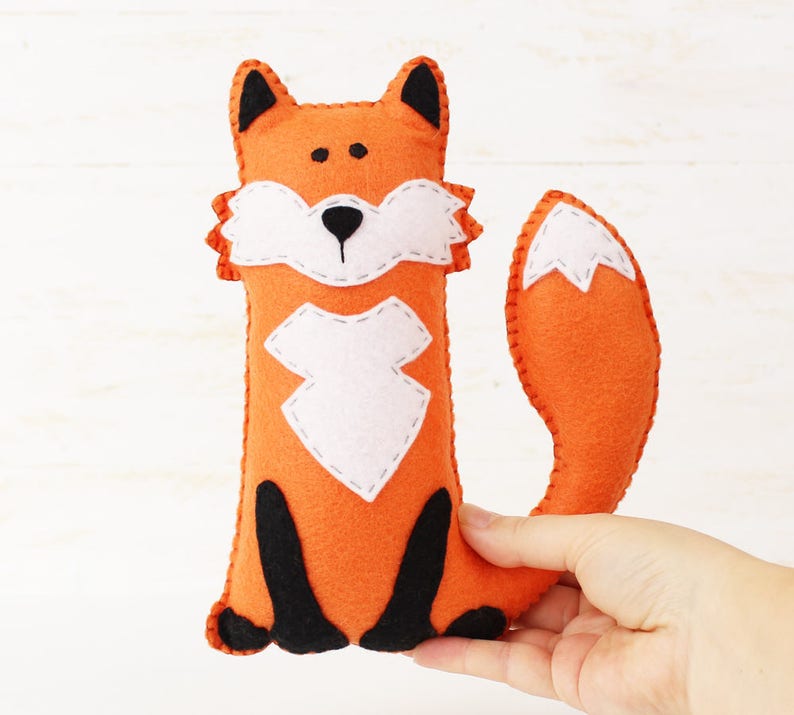 Hand holding a plush felt hand sewn fox