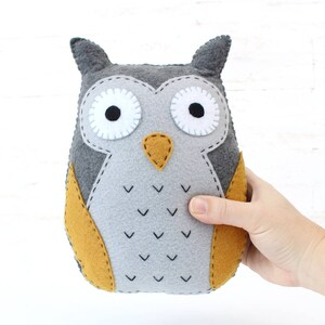 Hand holding a plush felt hand sewn owl