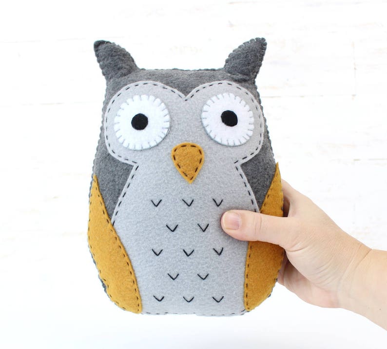 Hand holding a plush felt hand sewn owl