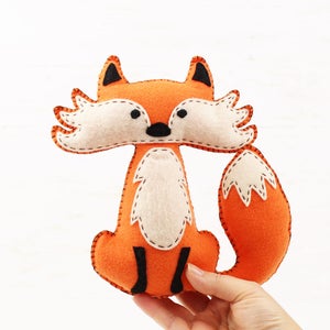 Orange handmade felt fox held in a hand