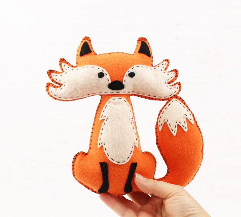 Orange handmade felt fox held in a hand