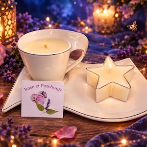 Pode incluir: Uma vela em chávena de cerâmica branca e uma vela em forma de estrela num pires branco a condizer. Um cartão quadrado com o texto Rose et Patchouli e uma ilustração de uma rosa e uma folha de patchouli está colocado à frente.