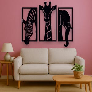 May include: Black metal wall art featuring a zebra, giraffe, and elephant, each within a rectangular frame. The artwork is mounted on a pink wall above a beige sofa and wooden coffee table, creating a modern safari theme.