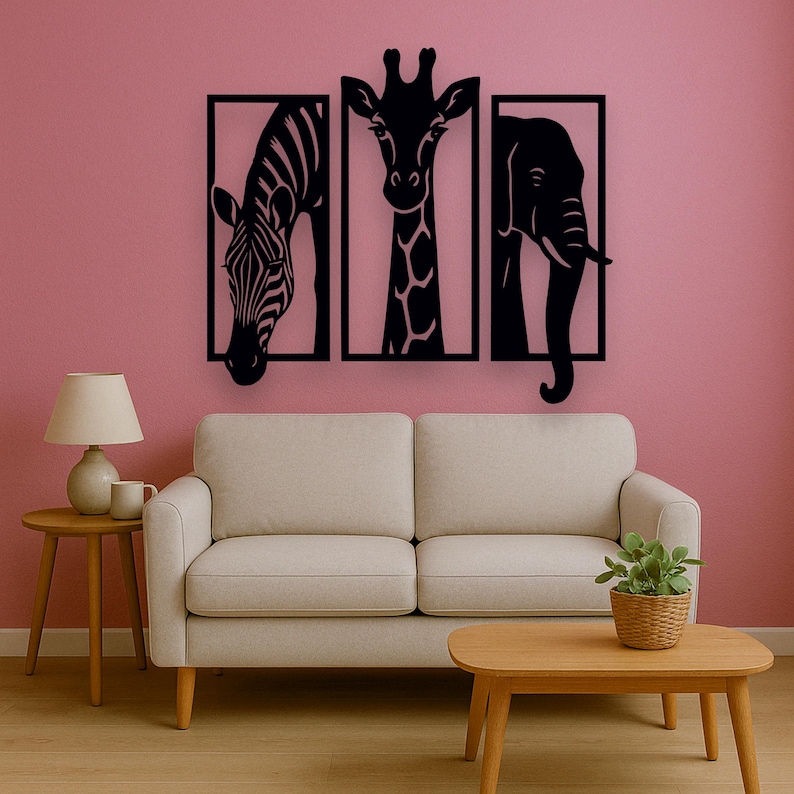 May include: Black metal wall art featuring a zebra, giraffe, and elephant, each within a rectangular frame. The artwork is mounted on a pink wall above a beige sofa and wooden coffee table, creating a modern safari theme.