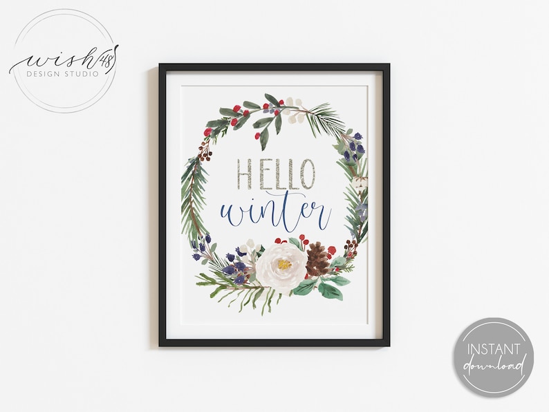 May include: A printable art print with a watercolor wreath of winter greenery, berries, and a white flower. The text "Hello Winter" is written in the center of the wreath in a silver glitter font.
