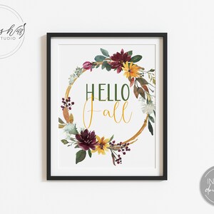 May include: A printable art print with a watercolor wreath of fall foliage, flowers, and berries. The wreath is gold and has the text "HELLO fall" in the center.