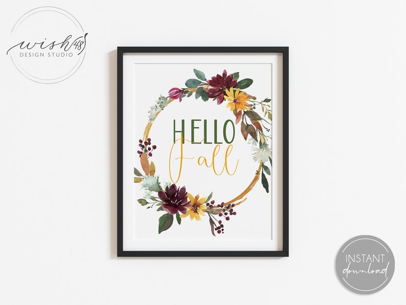 May include: A printable art print with a watercolor wreath of fall foliage, flowers, and berries. The wreath is gold and has the text "HELLO fall" in the center.