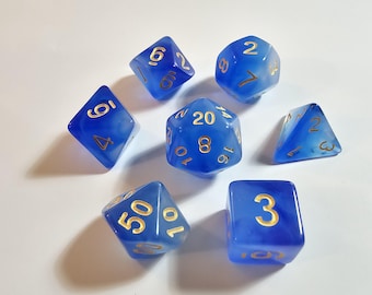 May include: A set of seven polyhedral dice in a translucent blue marbled finish with gold-colored numbers. The collection includes a d20, d12, d10, d8, d6, d4, and a percentile die, all featuring clear, legible numerals for tabletop gaming.